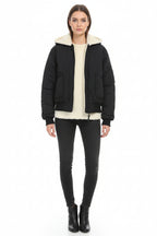 A reversible faux fur coat with a hood, displayed in black, green, and beige colors, with the hood on and detachable collar visible.